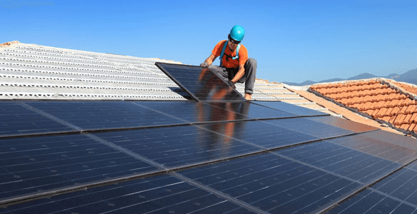 Technician installing solar panels on a residential roof